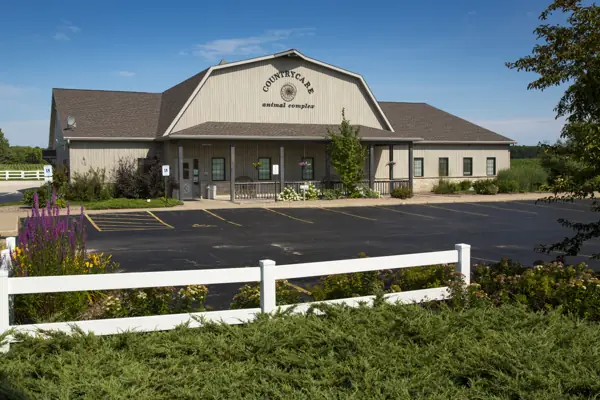 The Countrycare Animal Complex building behind a white rail fence and flower beds