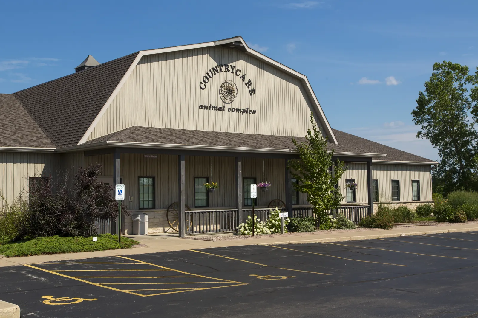 The Countrycare Animal Complex building, a barn-style clinic with its name on the gable, under a blue sky