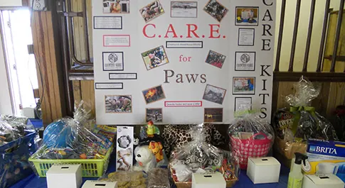 A C.A.R.E. for Paws display board above pet-themed raffle baskets